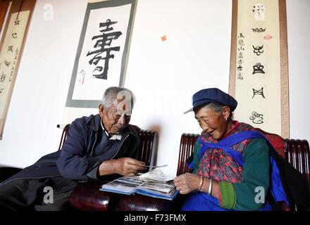 Yulong cinese della provincia dello Yunnan. 24 Novembre, 2015. Una coppia di anziani di Naxi locale gruppo etnico di sfogliare un album di famiglia a casa in Tianhong Village, situato ad una altitudine di circa 3000 metri, in Yulong Naxi contea autonoma, a sud-ovest della Cina di Provincia di Yunnan, nov. 24, 2015. © Yang Zongyou/Xinhua/Alamy Live News Foto Stock