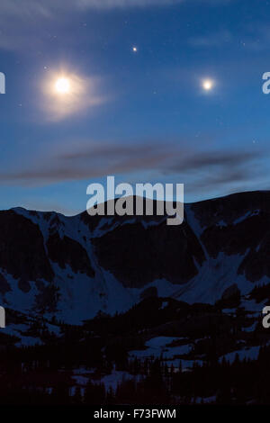 Venere e Giove formano un triangolo perfetto con una mezzaluna sopra la Snowy Range, Medicine Bow National Forest, Wyoming Foto Stock