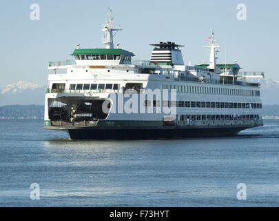 Seattle, Washington, Stati Uniti d'America. Xxi Nov, 2015. Il Washington State Ferry sistema, operando sotto il Dipartimento dei trasporti, gestisce circa due dozzine di fatto appositamente ferries lungo 10 percorsi diversi per 20 diversi terminali situati all'interno di Puget sabbia e il San Juan Islands. Come parte della Stato di Washington il sistema autostradale, il distintivo verde e pitturato di bianco carena è facilmente riconoscibile visivamente. --- In foto, la MV Puyallup si avvicina al terminale di Seattle in ingresso da Bainbridge Island con la Olympic Mountain Range visibile in distanza. © David Bro/ZUMA filo/Alamy Live News Foto Stock