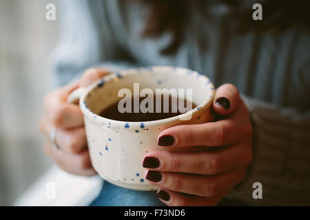 Giovane donna mani tenendo una tazza. Foto Stock