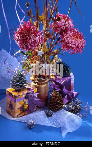 Festive Capodanno Natale ancora in vita con due regali di Natale, un bouquet di fiori di rosa crisantemi e coni . Foto Stock