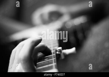 Immagine in bianco e nero di un maschio lettore banjo praticare alcune canzoni folk Foto Stock