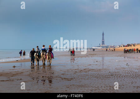 Asino passeggiate sulla spiaggia di Blackpool con il molo nord e la mitica Torre a distanza Foto Stock