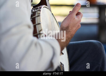 Close-up Azione girato di un ragazzo giocando banjo all'esterno. Foto Stock