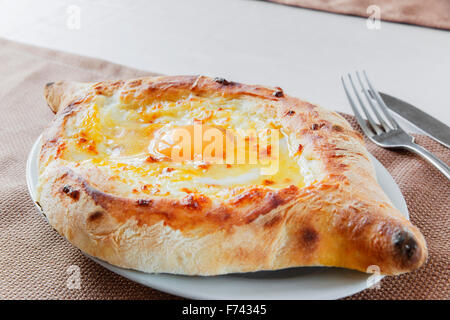 Khachapuri con formaggio e uova su una piastra Foto Stock