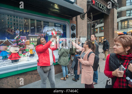 La folla di visitatori a Macy's Herald Square a New York Visualizza il 'A Charlie Brown Christmas'' themed la vetrina natalizia di Domenica, 22 novembre 2015. I quattro principali delle catene di grandi magazzini, Macy's, JCPenney, Kohl e Nordstrom sono tenuti a riferire una media di soltanto 1,2% la crescita dei ricavi nel terzo trimestre rispetto al 10% stimato per i discount. (© Richard B. Levine) Foto Stock