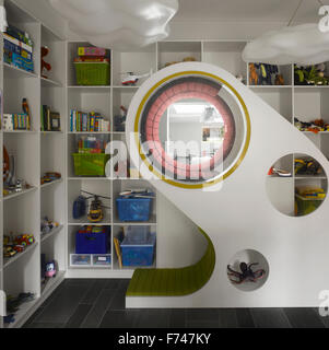 Sala giochi per bambini con playpod affacciato sulla cucina a Holland Park House da Paolo Archer Design, Londra, Inghilterra, Regno Unito Foto Stock