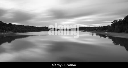 Bianco e nero immagine di panorama del lago al tramonto con esposizione lunga Foto Stock