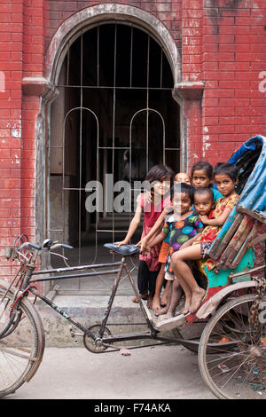 Dacca in Bangladesh 17 Novembre: i bambini di strada a giocare nella parte anteriore del vecchio edificio in vecchio Dhaka il 17 novembre 2015. Vecchia Dacca è un termine utilizzato per fare riferimento al vecchio centro storico della città di Dacca, capitale del Bangladesh moderno. Essa è stata fondata nel 1608 come Jahangir Nagar, la capitale del Bengala Mughal. Foto Stock