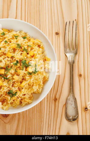 Risotto alla zucca sulla piastra bianca e tavolo in legno Foto Stock