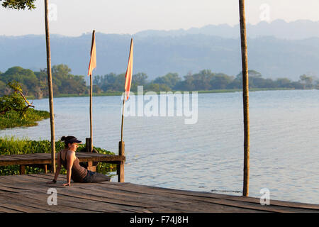 Una giovane donna siede sulla banchina del Lago Catemaco a Veracruz, Messico. Foto Stock
