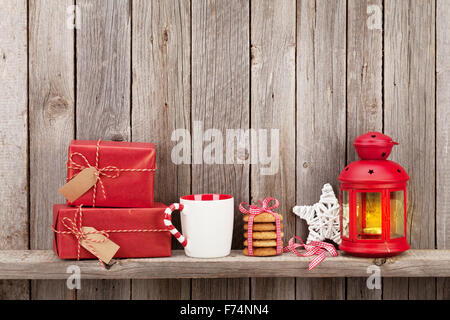 Christmas candle lanterna, confezioni regalo e decor e nella parte anteriore della parete di legno con spazio di copia Foto Stock