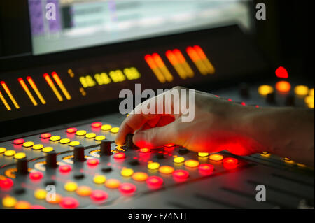 Maschio a mano il fader di controllo sul film console di miscelazione Foto Stock