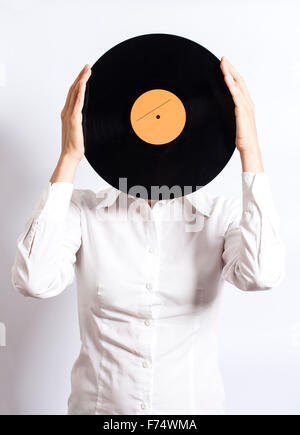 Donna che mantiene il record di vinile su viso Foto Stock