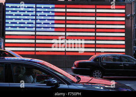 Rosso, bianco e blu ci neon bandiera fuori il Times Square Forze Armate stazione di reclutamento si riflette sul nero limousine Foto Stock