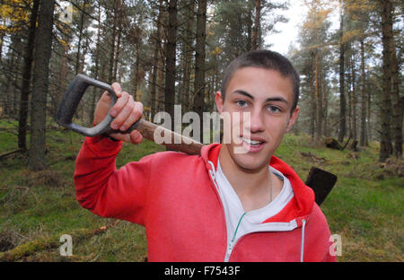 Ragazzo adolescente con la pala a scavare nella foresta. Foto Stock