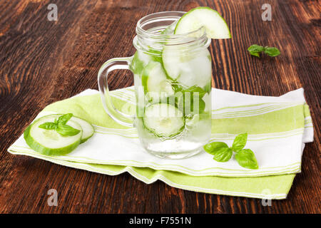 Il cetriolo e basilico limonata sul legno marrone vintage rustico tavolo. Una sana bevanda estiva. Foto Stock