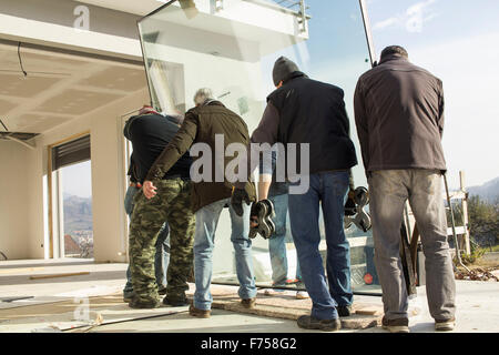 Lavoratori edili installazione di nuove finestre in una casa in costruzione nel Nord Italia. Foto Stock