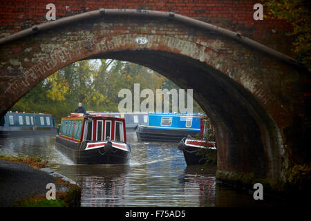 Alvechurch in Worcestershire marina fluviale boat yard blu nebbia canal autunno in movimento attraverso il ponte di arco sotto UK Gran Br Foto Stock