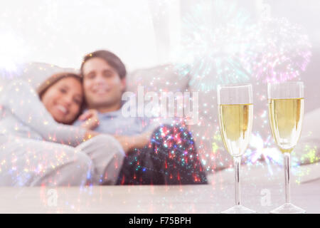 Immagine composita del giovane in appoggio su di un lettino con flauti di champagne Foto Stock
