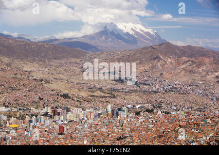 Il picco di Illimani (6343 metri) da El Alto sopra, La Paz, Bolivia. La Paz e El Alto sono criticamente a corto di acqua e probabilmente sarà la prima città capitale del mondo che dovrà essere in gran parte abbandonato a causa di mancanza di acqua. Essa si basa principalmente su acqua di disgelo glaciale dal circostante picchi andini, ma come il cambiamento climatico provoca i ghiacciai a fusione, si è rapidamente a corto di acqua. Foto Stock