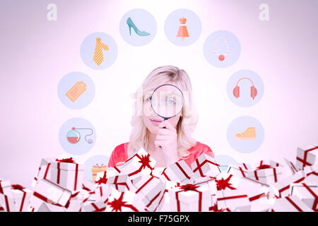 Immagine composita del biondo donna guardando attraverso una lente di ingrandimento Foto Stock