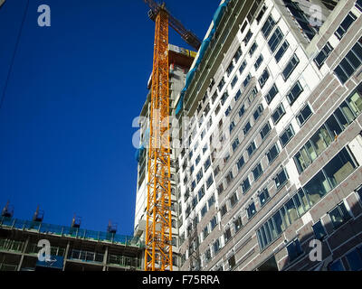 Una gru su un alto edificio sito Foto Stock