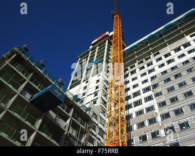 Una gru su un alto edificio sito Foto Stock