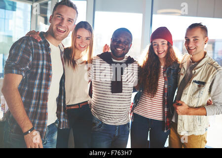 Un gruppo di adolescenti di gioiosa nel casual wear guardando la fotocamera Foto Stock