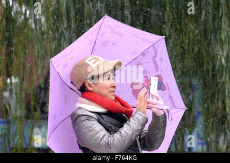 Jinan, la Cina della provincia dello Shandong. 25 Nov, 2015. Una donna prende le foto nella neve di Jinan, a est della capitale cinese della provincia dello Shandong, nov. 25, 2015. Credito: Feng Jie/Xinhua/Alamy Live News Foto Stock