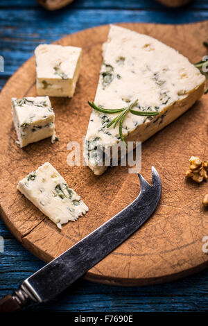 Formaggio con stampo sul tagliere di legno Foto Stock