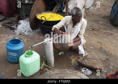 L'uomo acqua di riempimento nella brocca di argilla, pushkar, Rajasthan, India, Asia Foto Stock