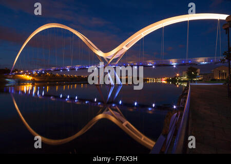 Tempo di notte vista dell'illuminato infinito ponte che attraversa il Fiume Tees a Stockton-on-Tees,Inghilterra Foto Stock