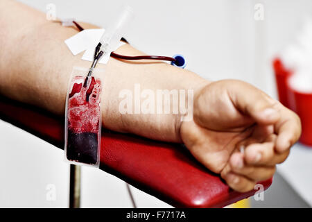 Dettaglio con la mano di un donatore di sangue e una plastica sacca di sangue in un ospedale Foto Stock