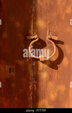 Porta vecchia respingente sul porta con uno sfondo blu. Uno strumento metallico ad una porta a battente e battuta dai visitatori per attirare atten Foto Stock