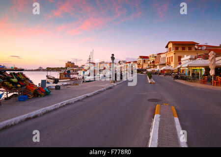 Vista del lungomare con i negozi di caffè, bar e ristoranti e barche da pesca nel porto di Aegina Island, Grecia Foto Stock