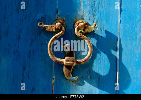 Porta vecchia respingente sul porta con uno sfondo blu. Uno strumento metallico ad una porta a battente e battuta dai visitatori per attirare atten Foto Stock