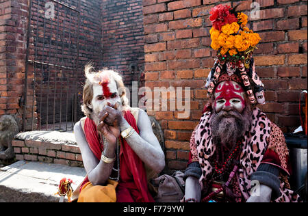 Due Sadhus indù (santi) fumatori weed al tempio di Pashupatinath complessa, Kathmandu, 2015, il Nepal Foto Stock