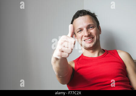Positivo sorridente giovane uomo caucasico mostra Thumbs up gesto, ritratto in studio Foto Stock