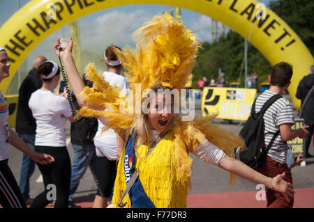 Ragazza in giallo in corrispondenza di una stazione di verniciatura per il colore Run - La più felice 5K sul pianeta Foto Stock