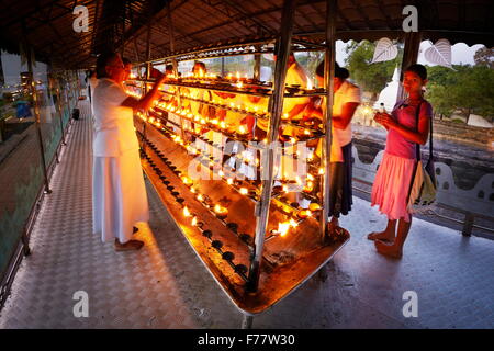 Sri Lanka, Kandy - pellegrini si accendono le candele nel tempio del Dente, Sri Dalada Maligawa, Patrimonio Mondiale dell UNESCO Foto Stock