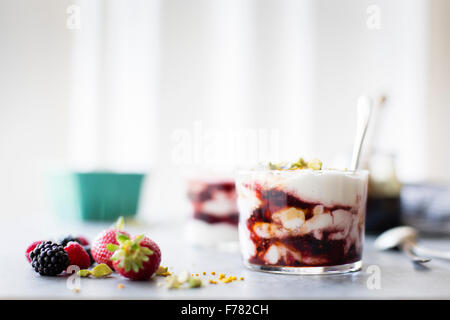 Estate bacche yogurt stolti dessert con il miele di grano saraceno. Foto Stock