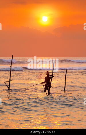 Stilt pescatori al tramonto tropicale, Koggala Beach, Sri Lanka, Asia Foto Stock