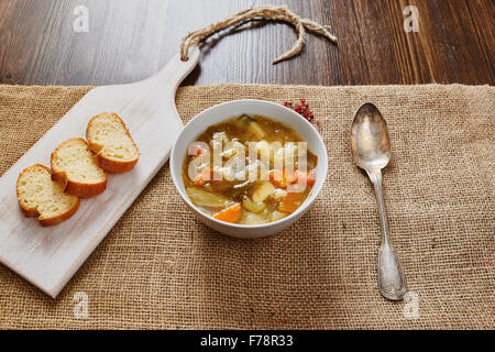 Zuppa di verdure in bianco ciotola di legno scuro tabella Foto Stock