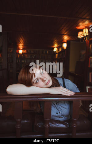 Bella studentessa in una biblioteca universitaria Foto Stock