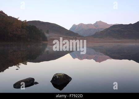 Una Veduta autunnale di The Langdale Pikes, preso all'alba da Blea Tarn nel Parco Nazionale del Distretto dei Laghi. Foto Stock