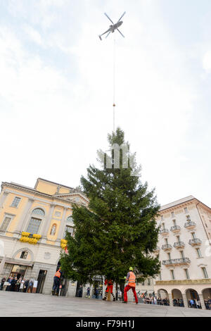 Lugano, Svizzera - 20 novembre 2015: i lavoratori che si spostano di un albero di Natale che viene depositato da un elicottero in squa centrale Foto Stock