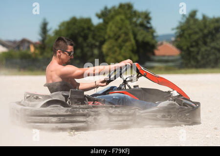 Giovane uomo è la guida Go-Kart Auto con velocità in un parco giochi Racing via - Go Kart è famosa per il tempo libero sport a motore Foto Stock