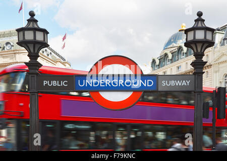 La metropolitana di Londra segno con lampade stradali e bus rosso a due piani sullo sfondo Foto Stock