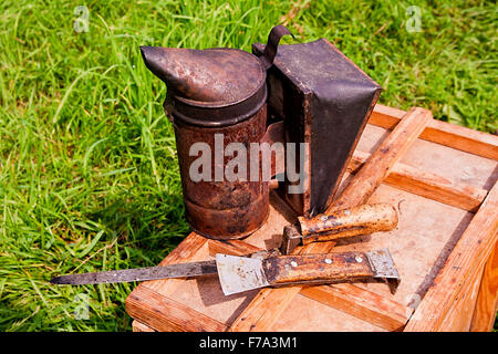 Vintage fumatore e diversi tipi di apicoltore coltelli sulla scatola di legno. Foto Stock